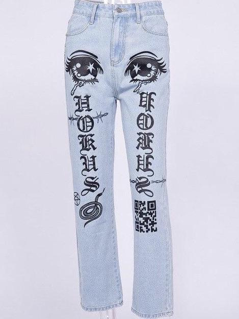 front view of our light blue jeans with two eyes at the top of the thighs, with gothic letters on the legs and snake, pentagram and qr code symbols in black