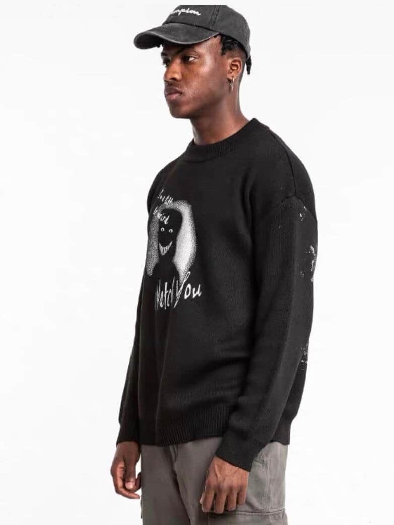 3/4 profile view of our black sweater with a creepy smiling silhouette shadow printed with the text watch you