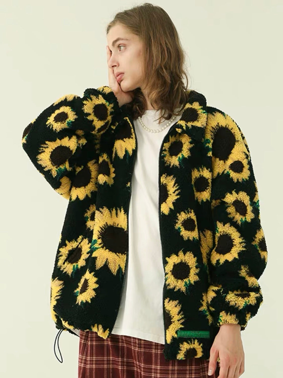 warm jacket with two front pockets and sunflowers printed on a plain black background that closes with a black zipper and adjustable by an elastic at the waist