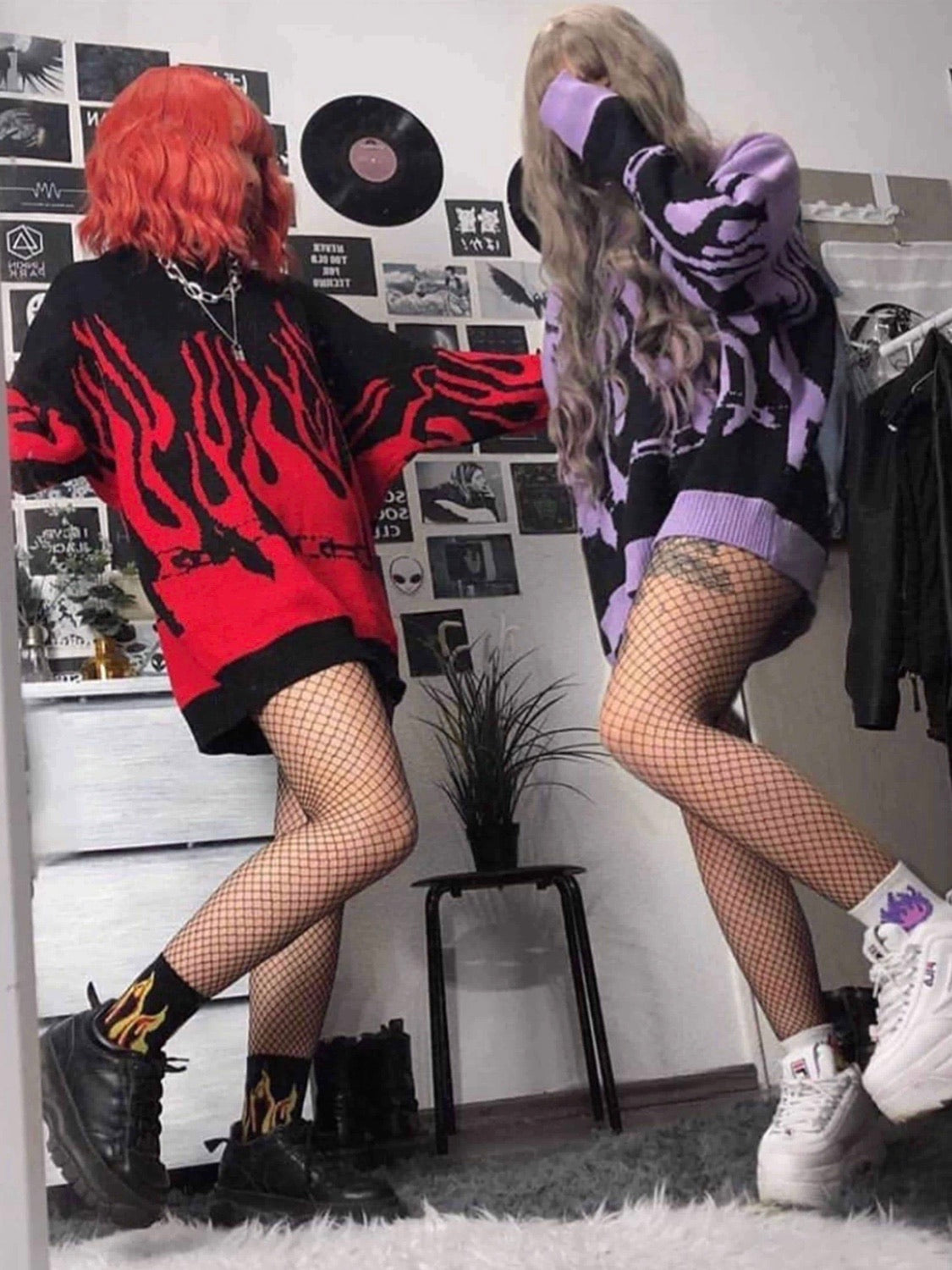 Two woman wearing the purple model and the red model sweater with flames