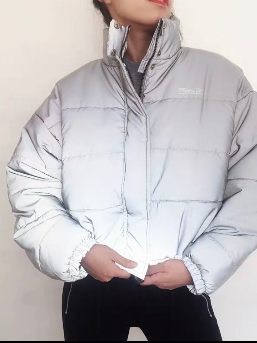 oversize reflective parka adjustable around the waist with a high collar worn