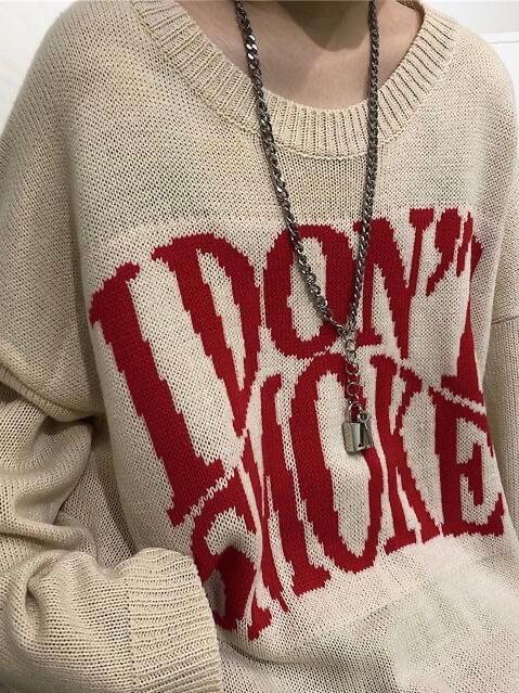 details of our apricot knitter sweater with I don't smoke written in big red letters on the chest