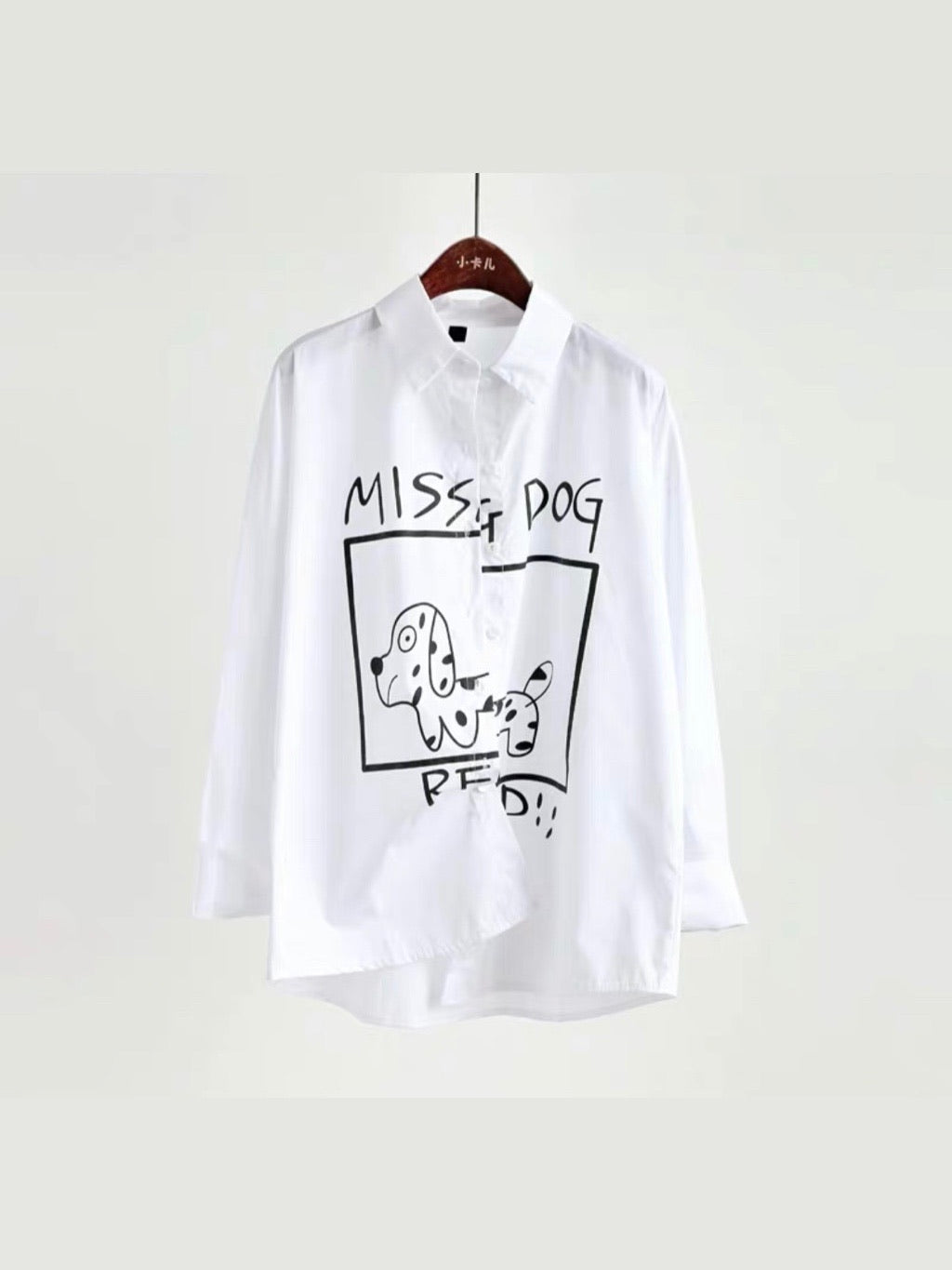 white shirt with a drawing of a missing dog split by the buttons that close the shirt with the text above missing dog and the text below red