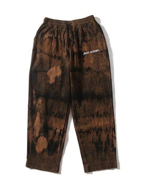 brown tie and dye velvet long pants vh studios with made extreme embroidered in white on the top of the left thigh. t has an elastic waist adjustable with a black  lace